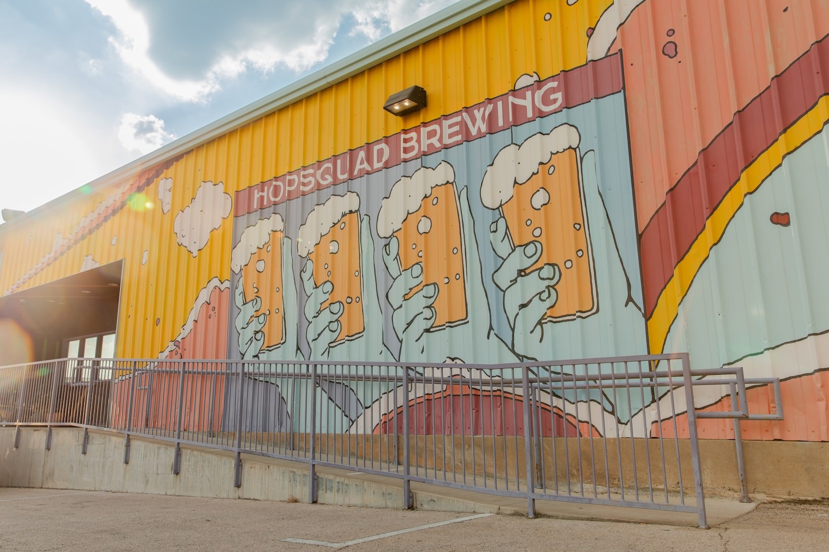 Hopsqaud Brewing large painting on a building with a ramp to the entrance